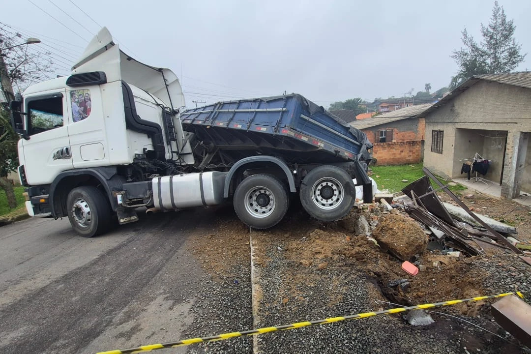 Carreta tomba em morro e atinge muro de residência em Criciúma; veja fotos